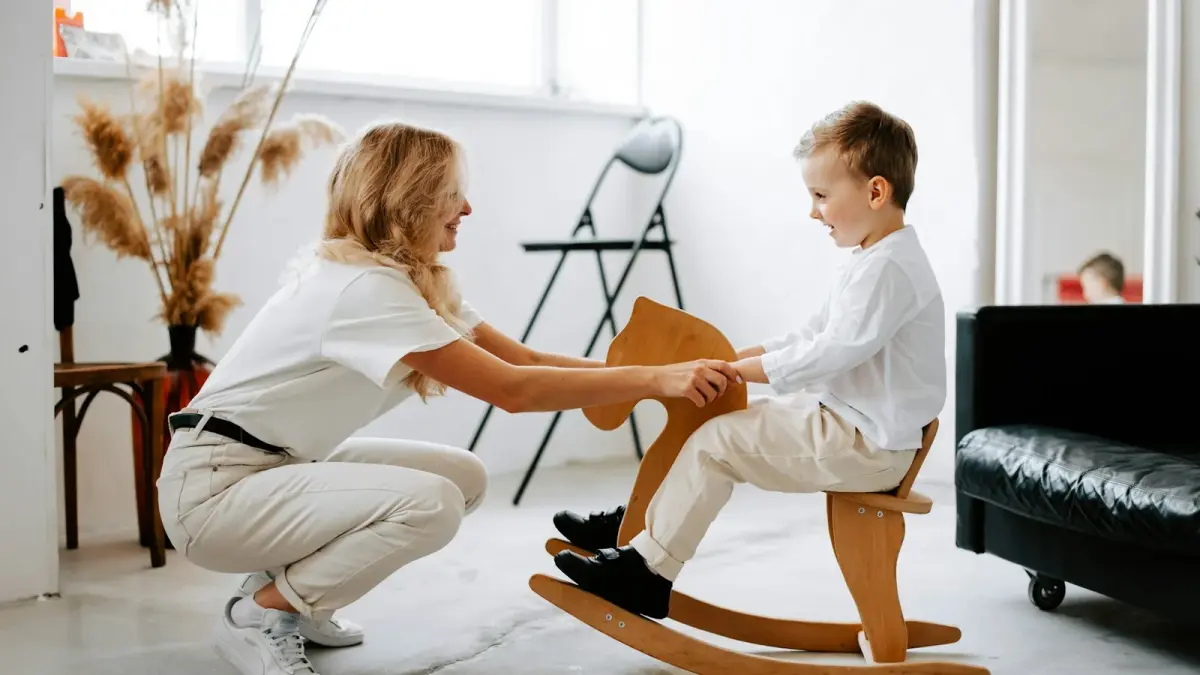Parent and child laughing together while reading a book