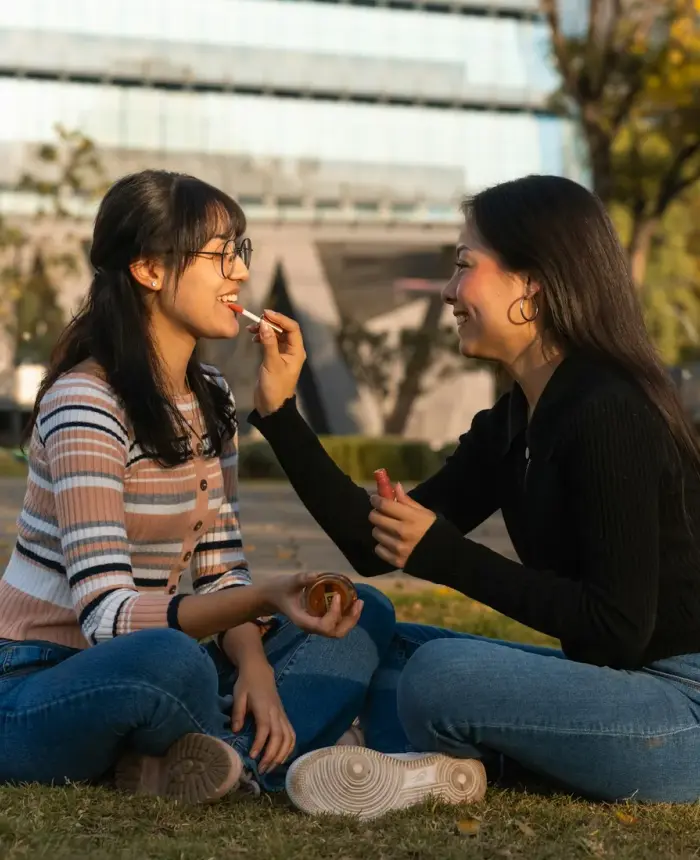 Two teens sharing a relaxed, judgment-free conversation on the grass